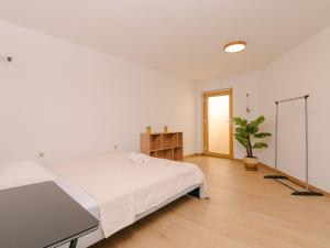 a white bedroom with a bed and a potted plant at Holiday Home A'more Preko Ferienhaus in Preko Insel Ugljan by Interhome in Preko
