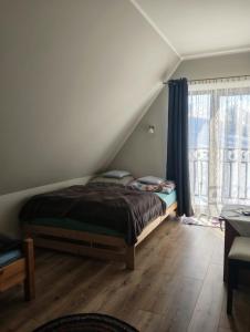 a bedroom with a bed and a window at Widlakówka in Rzepiska