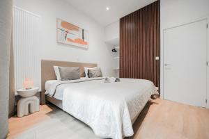 a white bedroom with a bed and a toilet at Appartement en plein centre-ville in Liège