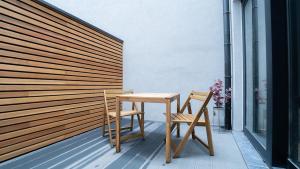 a wooden table and two chairs on a balcony at Appartement en plein centre-ville in Liège