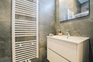 a bathroom with a white sink and a mirror at Appartement en plein centre-ville in Liège +4 photos