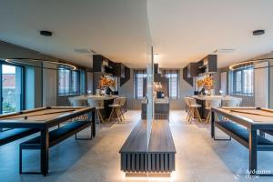 a restaurant with tables and chairs and windows at Loft La Suite et sa Suite in Thimister