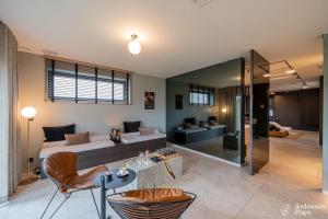 a bedroom with a bed and a living room at Loft La Suite et sa Suite in Thimister