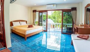 una camera con letto e pavimento piastrellato blu di Hugs Guesthouse a Ko Lanta