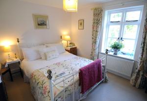 a bedroom with a white bed and a window at Blackbrook House in Holmwood