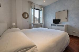 a bedroom with a large white bed and a television at Suite Mazzini in Ravenna
