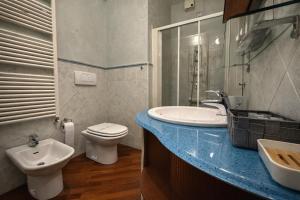 a bathroom with a white toilet and a sink at Suite Mazzini in Ravenna +11 photos