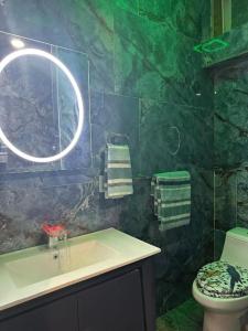 a green bathroom with a sink and a toilet at 420 Friendly Suites in Washington, D.C.