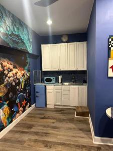 a kitchen with white cabinets and a painting on the wall at 420 Friendly Suites in Washington, D.C.