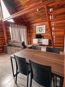 a dining room with a table and chairs and a couch at Vale dos Imigrantes in Bento Gonçalves