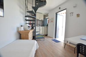 a room with a bed and a spiral staircase at Casinha in Sintra
