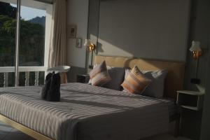 a bedroom with a large bed with a window at Residy Hideaway in Patong Beach