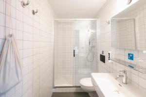 a bathroom with a shower and a toilet and a sink at People Lyon Hotel in Lyon +38 photos