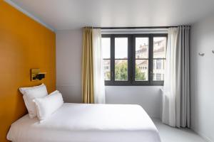 a bedroom with a white bed and a window at People Lyon Hotel in Lyon