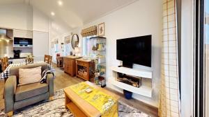 a living room with a flat screen tv on a wall at Low Lake Lodge - Lakeside - Part of the The Bay Filey Holiday Village with pool, gym and direct beach access, pub, restaurant, tennis and meadows walks in Reighton