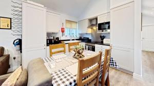 a kitchen and dining room with a table and chairs at Low Lake Lodge - Lakeside - Part of the The Bay Filey Holiday Village with pool, gym and direct beach access, pub, restaurant, tennis and meadows walks in Reighton +45 photos