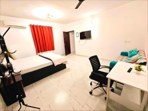 a small room with a bed and a desk and a table at A2 Villa by JMD - Peaceful Stay Near Expo Mart in Greater Noida +7 photos