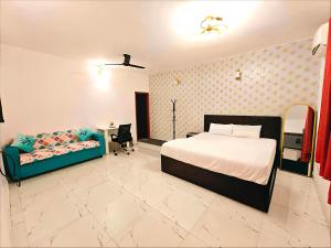 a bedroom with a bed and a couch at A2 Villa by JMD - Peaceful Stay Near Expo Mart in Greater Noida
