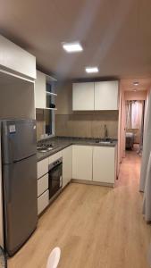 a kitchen with white cabinets and a stainless steel refrigerator at Casa container Hermosa zona in Paraná