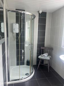 a shower with a glass door in a bathroom at Campbell's Cottage in Blackwatertown +48 photos
