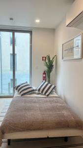 a bedroom with a large bed with a large window at D'AUSE - New Modern Apt - 150m to Beach & Center in Esposende