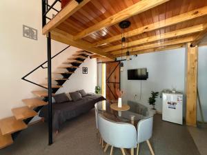 a living room with a glass table and a spiral staircase at Elvira in Estación Circunvalación