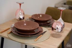 a table with plates and bowls and wine glasses at Le Cocon Love Room & Spa in Nancy