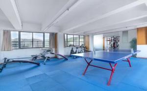 a gym with a ping pong table and two exercise bikes at Shenzhen Xingwei Yifeng Hotel in Shenzhen