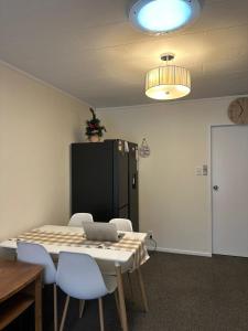a room with a table and chairs with a laptop on it at Sochi A double bed Room in a nice home in Upper Hutt