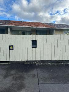 a white fence in front of a house at Sochi A double bed Room in a nice home in Upper Hutt