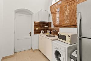 a kitchen with a washing machine and a microwave at The Downtown Getaway Studio in Hurghada +15 photos