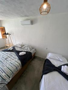 a bedroom with two beds and a light fixture at Suíte Adam 1 em Caraíva com piscina 900m da Vila in Caraíva +14 photos