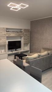 a living room with a couch and a flat screen tv at Oltre Le Onde in Nova Siri Marina