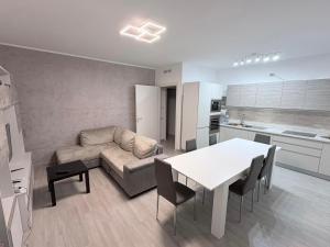 a kitchen and a living room with a table and a couch at Oltre Le Onde in Nova Siri Marina