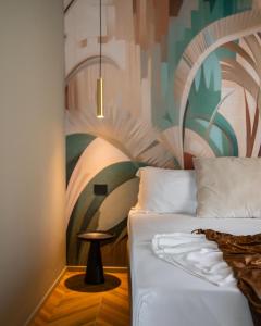 ein Schlafzimmer mit einem Bett und einem Gemälde an der Wand in der Unterkunft Rock Crystal Boutique Hotel in Gabicce Mare