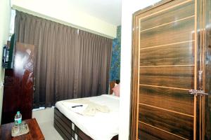 a bedroom with a bed and a wooden door at Sri Sai comforts - Bannerghatta Main Road in Bangalore +29 photos