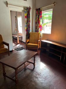 a living room with a table and chairs and a couch at Maison Baby plein centre in Ambatoloaka