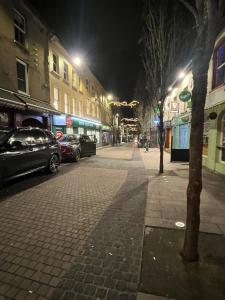 a city street at night with cars parked at Cosy Townhouse 2bedroom in Enniscorthy