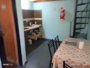 a room with a table and chairs and a sink at Los Gurises in Gualeguay