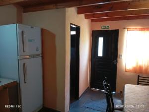 a kitchen with a white refrigerator and a black door at Los Gurises in Gualeguay