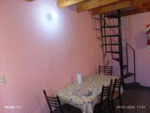 a dining room with a table and a spiral staircase at Los Gurises in Gualeguay +28 photos