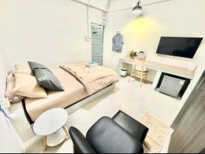 a small room with a bed and a desk at อมรรัตน์Room in Pathum Thani