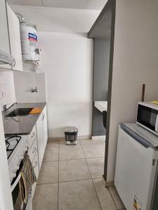 a small kitchen with a sink and a stove at Bahia Rental 11-Departamento x dia con cochera in Bahía Blanca