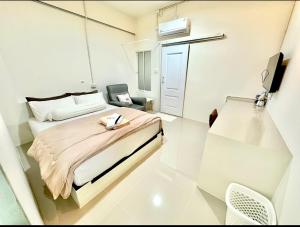 a small white room with a bed and a chair at อมรรัตน์Room in Pathum Thani
