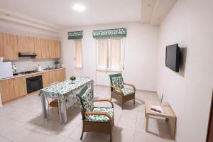 a living room with a table and chairs and a kitchen at Il Tulipano Camera con bagno privato a Marcianise in Marcianise