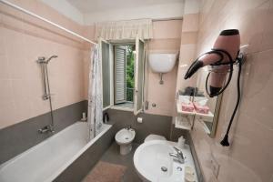 a bathroom with a sink and a toilet and a bath tub at Il Tulipano Camera con bagno privato a Marcianise in Marcianise