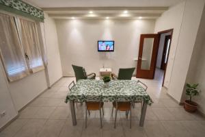 a dining room with a table and chairs and a tv at Il Tulipano Camera con bagno privato a Marcianise in Marcianise
