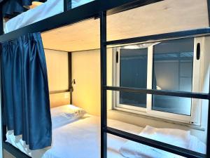 two bunk beds in a room with a window at PMG Hostel in Tirana