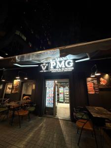 a bong restaurant at night with tables and chairs at PMG Hostel in Tirana