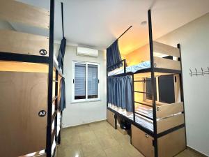 a room with three bunk beds and a window at PMG Hostel in Tirana